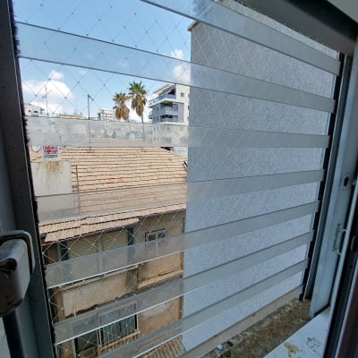 רשת יונים מותקנת על חלון למניעת כניסת יונים