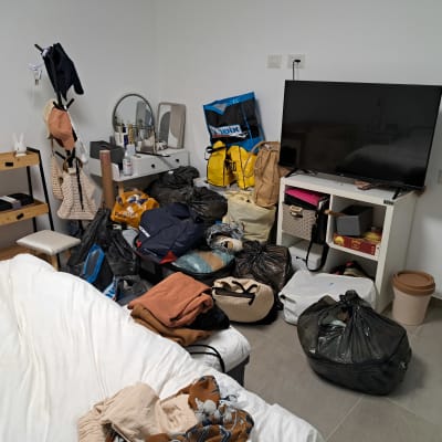 חדר מבולגן עם בגדים ופריטים מפוזרים