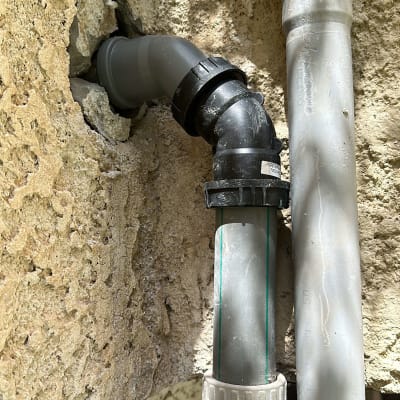 צינורות פלסטיק מחוברים לקיר אבן