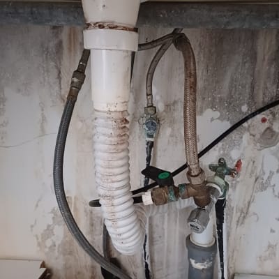 צינורות מים וברזים מתחת לכיור מטבח