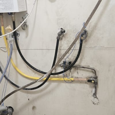 צינורות גז ומים מחוברים לקיר עם ברזים