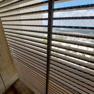 רשת יונים מותקנת על חלון למניעת כניסת יונים