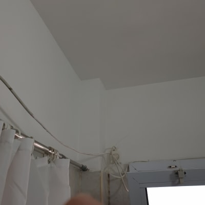 קיר ותקרה צבועים בלבן עם חוטים חשמליים