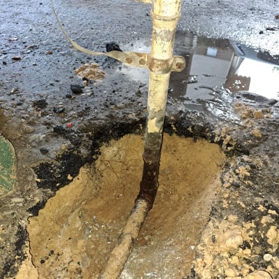 צינור מים חלוד עם חיבורי ברזל באדמה רטובה