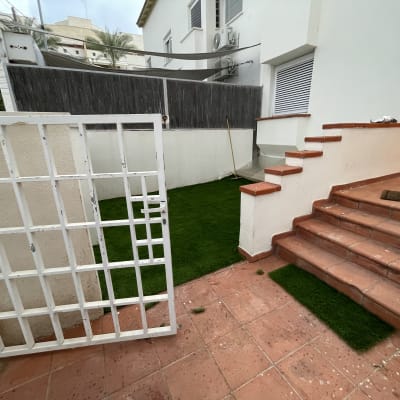 דשא סינתטי מונח על הקרקע ליד מדרגות