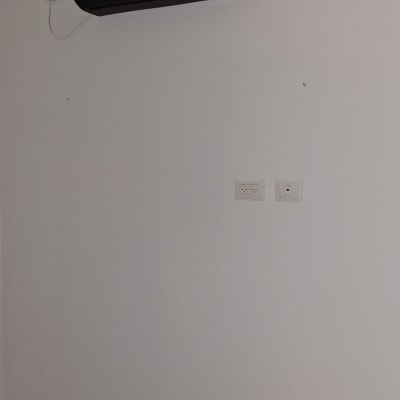 חדר עם מזגן ומאוורר תקרה מעל מיטה