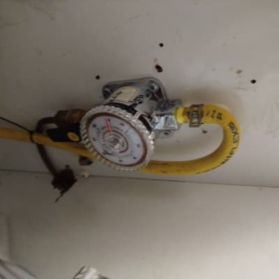 מד גז מחובר לצינור צהוב בתוך ארון