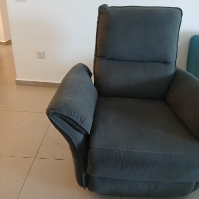 כורסה מרופדת בצבע כהה בחדר פנימי