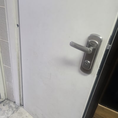 ידית דלת מתכתית על דלת לבנה