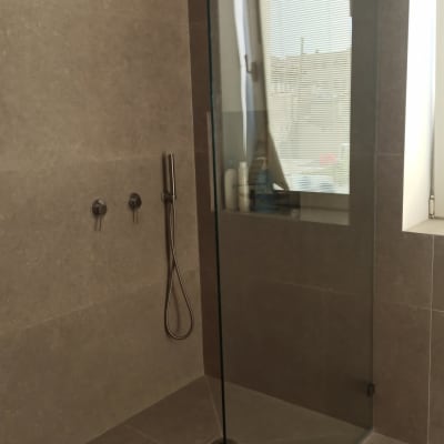 מקלחת עם ראש גשם ודלת זכוכית