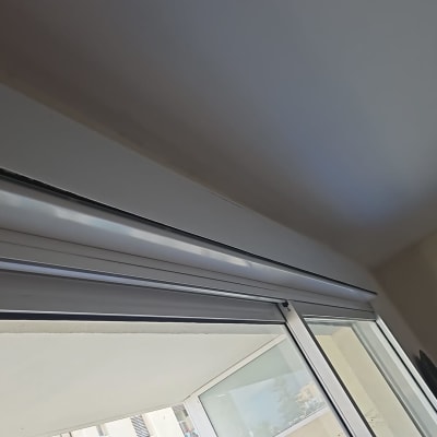 תריסים לבנים מותקנים על חלון זכוכית