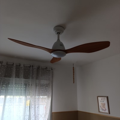 מאוורר תקרה בחדר עם וילון ותמונה על הקיר