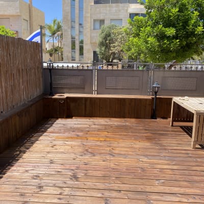 דק עץ עם שולחן עץ וגדר במבוק