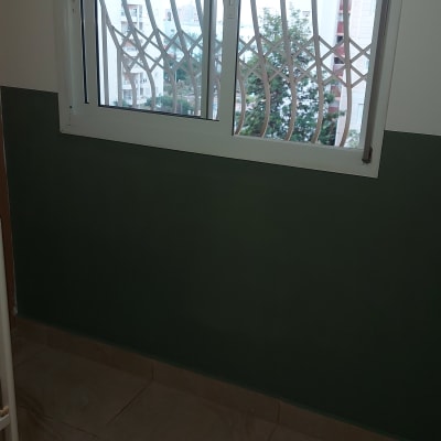 קיר צבוע בחצי ירוק וחצי לבן מתחת לחלון