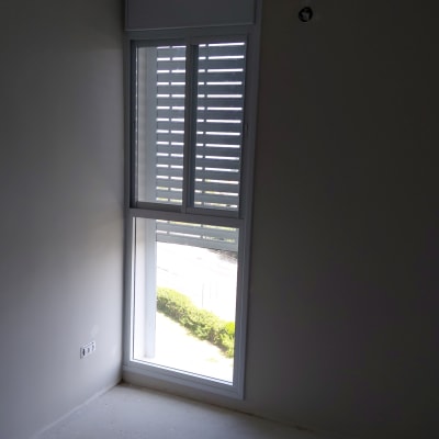 חלון אלומיניום עם תריסים בחדר ריק