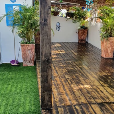 פרגולה מעץ עם רצפת דק וצמחייה מסביב