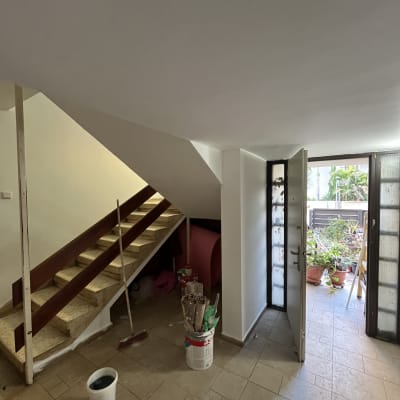 דלי צבע ומברשות ליד מדרגות בבית