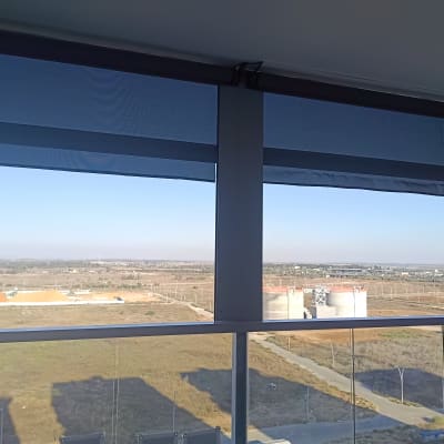 סוככים כחולים מותקנים על מרפסת עם נוף פתוח