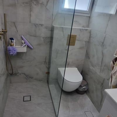 מחיצת זכוכית במקלחת עם חיבורי מתכת