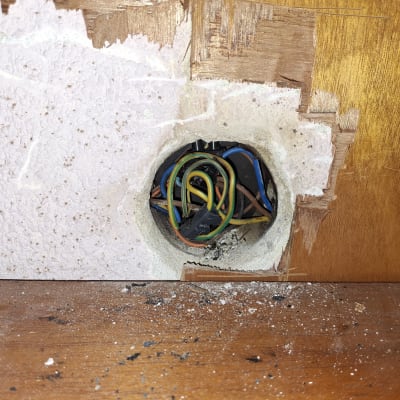 חוטי חשמל צבעוניים יוצאים מקיר עץ