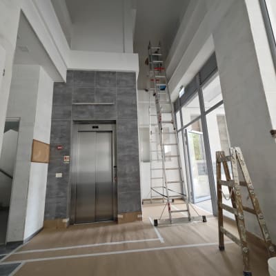 סולם גבוה ליד קיר צבוע בלבן