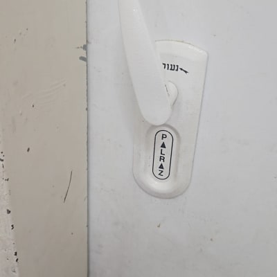 ידית דלת לבנה עם כיתוב פלרז ונעול