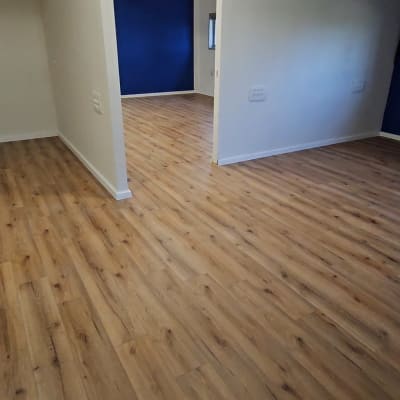 רצפת פרקט עץ בחדר ריק עם קירות לבנים