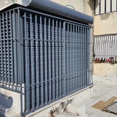 סורגים מתכתיים אפורים על חלון בניין