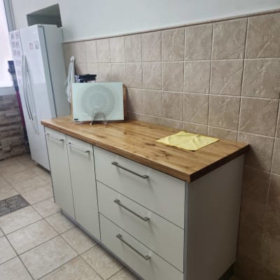 ארונות מטבח עם משטח עץ, קרש חיתוך ומקרר