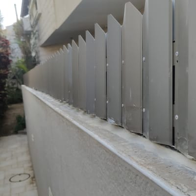 גדר מתכת עם ברגים על קיר בטון