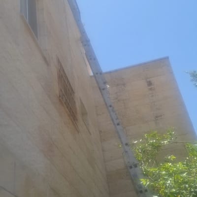 סולם מונח על קיר בניין לאיטום