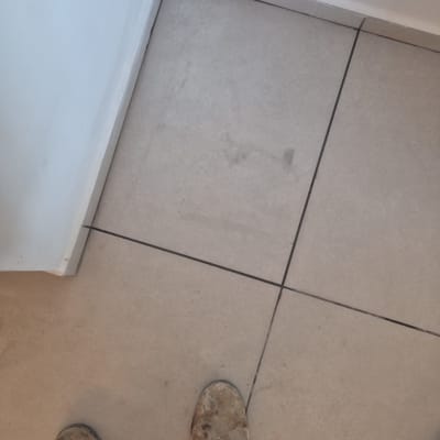 רצפה מרוצפת עם מגפיים מלוכלכים בפינת חדר