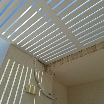 פרגולה לבנה עם צינור על קיר חיצוני