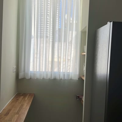 וילון לבן שקוף תלוי על חלון גבוה