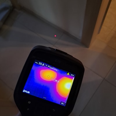 מד חום תרמי מציג אזורים חמים על הרצפה