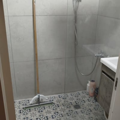 מקלחת עם רצפה מעוצבת וכלי ניקוי