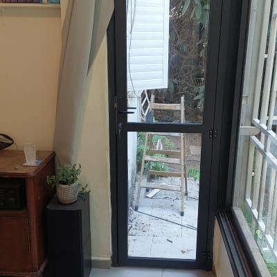 דלת אלומיניום עם חלון וסולם בחוץ