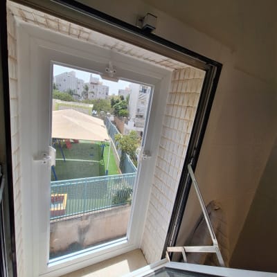 חלון אלומיניום פתוח עם נוף חיצוני