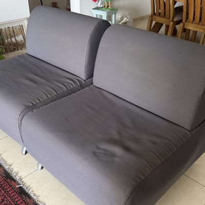 ספה אפורה על שטיח אדום בחדר מגורים