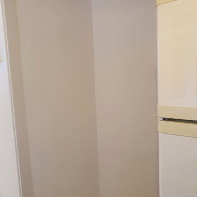 קיר צבוע בלבן ליד מקרר בז