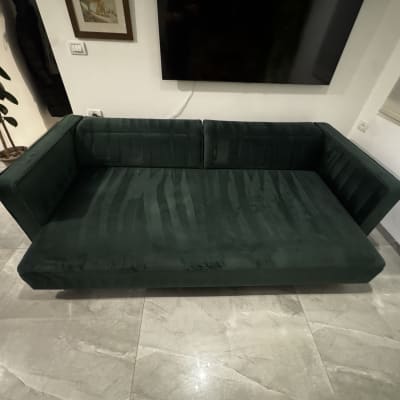 ספה ירוקה בחדר מגורים עם רצפת שיש