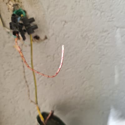 חוטי חשמל חשופים יוצאים מקיר עם חיבורי פלסטיק