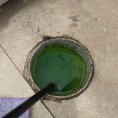 צינור עם נוזל ירוק בבור ניקוז