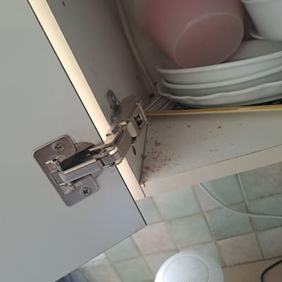 ארון מטבח פתוח עם צירים, כלים ואבק