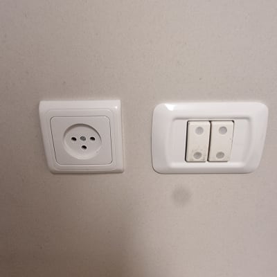 שקע חשמל ומתגי תאורה על קיר