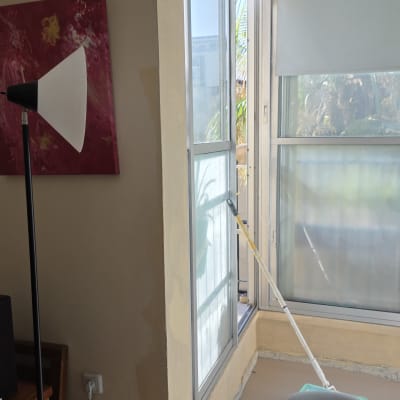 חלון עם וילון וכלי צביעה לידו