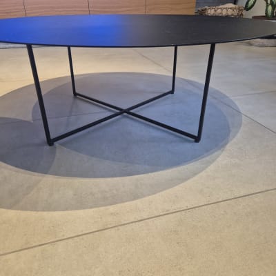 שולחן עגול עם רגלי מתכת על רצפת אריחים