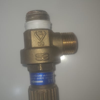 שסתום מתכת עם תווית כחולה על רקע לבן