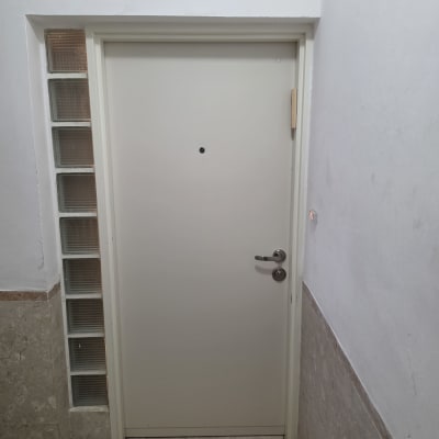 דלת לבנה עם ידית מתכת בקיר לבן