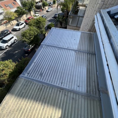 גג עם כיסוי שקוף ונוף עירוני ברקע